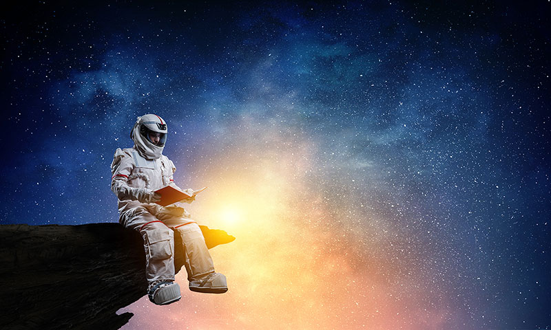 Ceo dezen Astronaut čita na ivici stene